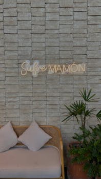 Stylish lounge featuring a neon sign and cozy seating against a textured wall.